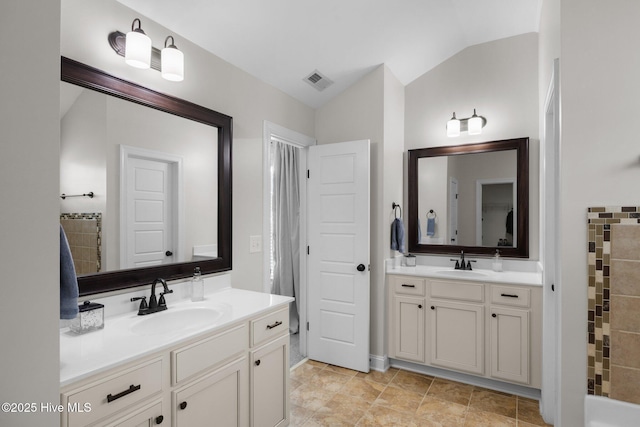 bathroom featuring vaulted ceiling and vanity