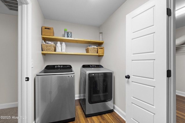 clothes washing area featuring dark wood-type flooring and washing machine and dryer