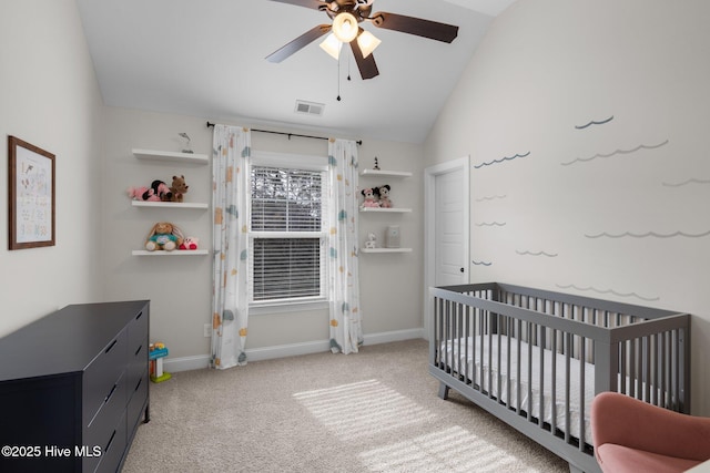 bedroom featuring a crib, vaulted ceiling, light colored carpet, and ceiling fan