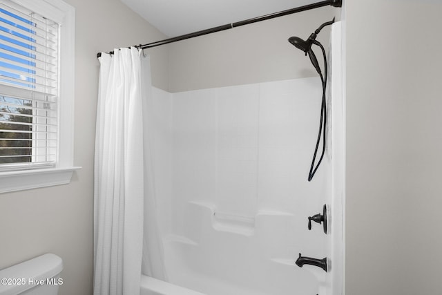 bathroom with toilet and shower / bath combo with shower curtain