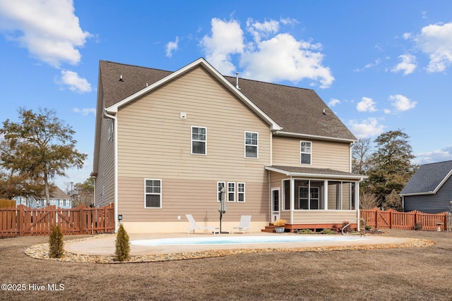 back of property with a sunroom and a patio area