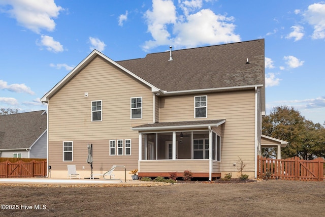 rear view of property featuring a yard, a sunroom, and a patio