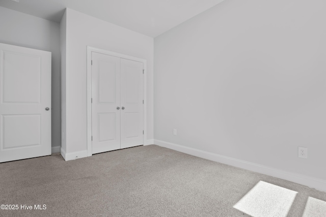 unfurnished bedroom with carpet, baseboards, and a closet