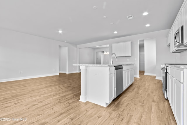 kitchen featuring light wood finished floors, visible vents, appliances with stainless steel finishes, a kitchen island with sink, and white cabinets