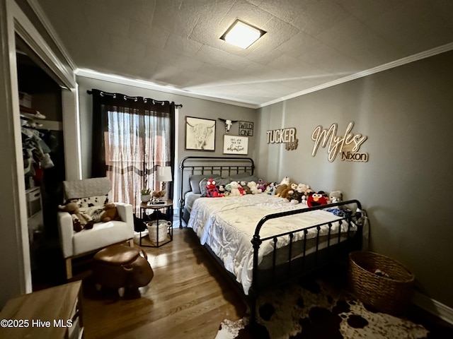 bedroom with hardwood / wood-style flooring and ornamental molding