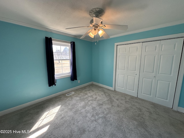 unfurnished bedroom featuring light colored carpet, visible vents, a textured ceiling, and baseboards