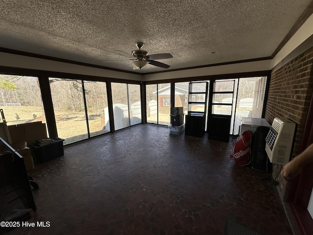 unfurnished sunroom featuring a ceiling fan and heating unit