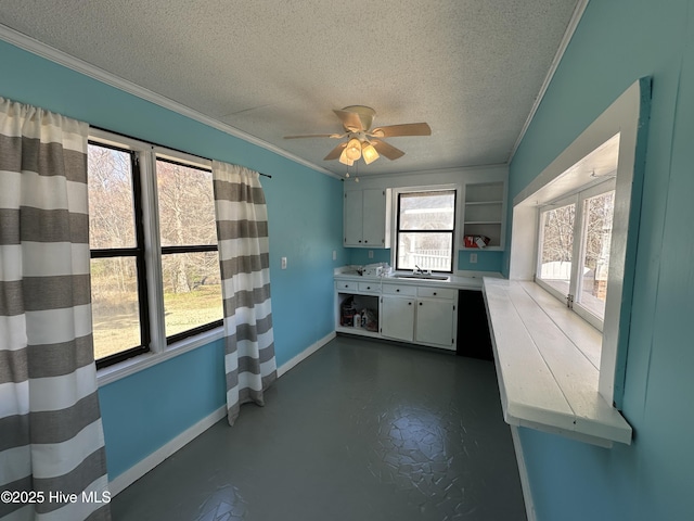 kitchen featuring crown molding, light countertops, and white cabinets