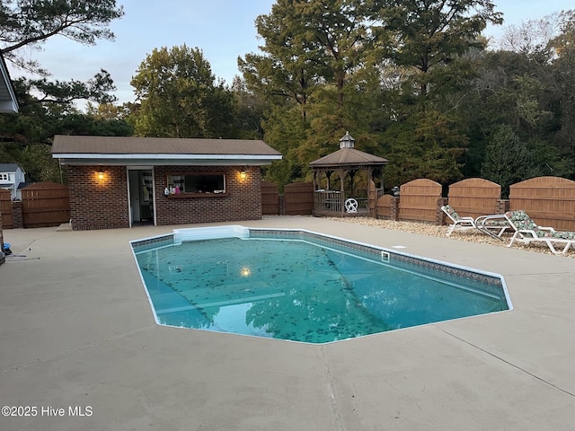 view of swimming pool with a fenced backyard, an outdoor structure, a gazebo, a fenced in pool, and a patio area