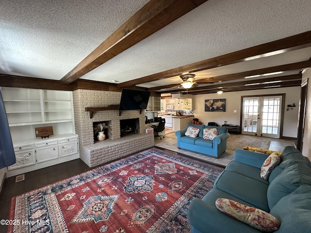 living room with a textured ceiling, wood finished floors, french doors, a brick fireplace, and beamed ceiling