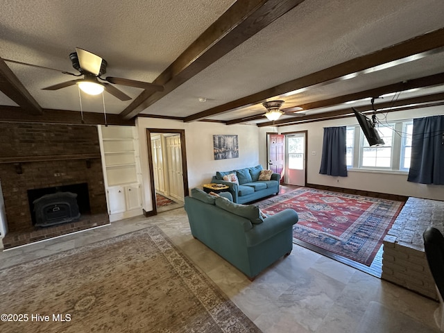 living area with baseboards, a textured ceiling, a ceiling fan, and beamed ceiling