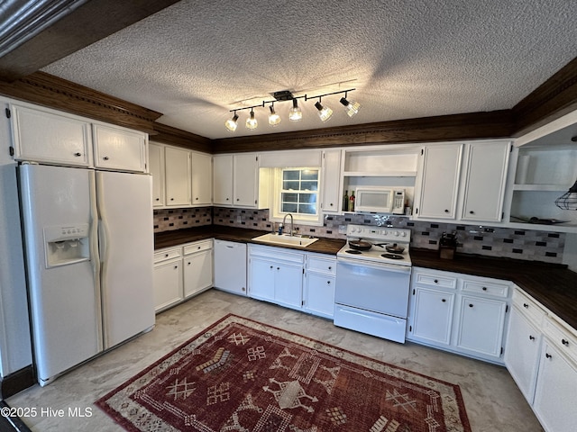 kitchen with white appliances, dark countertops, a sink, white cabinetry, and backsplash