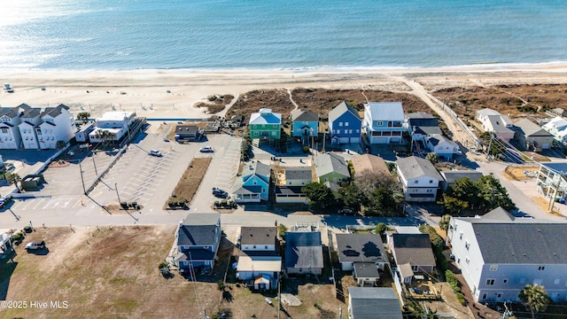 birds eye view of property with a water view and a beach view