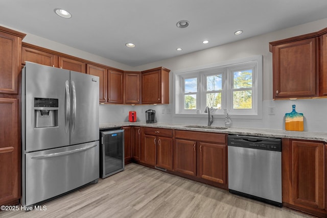 kitchen featuring sink, tasteful backsplash, stainless steel appliances, beverage cooler, and light stone countertops