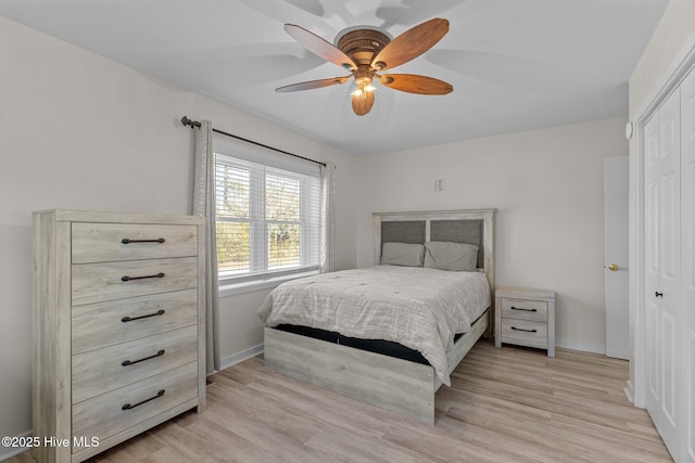 bedroom featuring ceiling fan, light wood-type flooring, and a closet