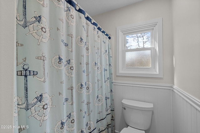 bathroom with a shower with shower curtain and toilet