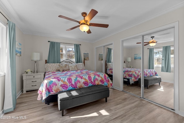 bedroom with multiple closets, ornamental molding, and light hardwood / wood-style flooring