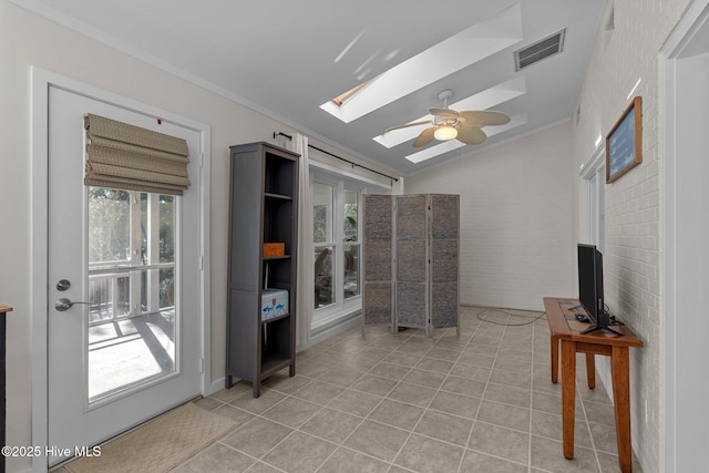 interior space with french doors, lofted ceiling with skylight, crown molding, light tile patterned floors, and ceiling fan