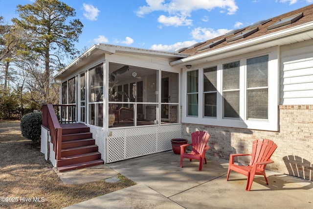 rear view of property featuring a sunroom and a patio area