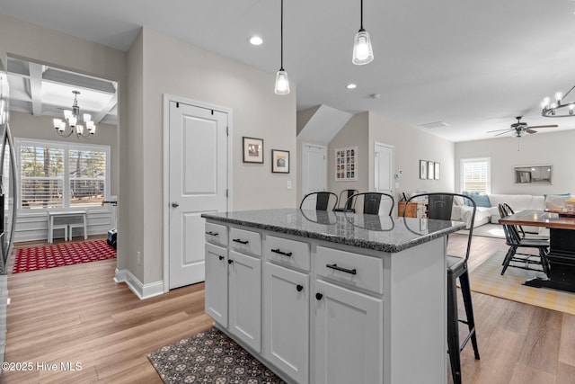 451 Gretchen Rd, West End, NC 27376 - kitchen with light wood finished floors, a center island, a kitchen bar, and ceiling fan with notable chandelier