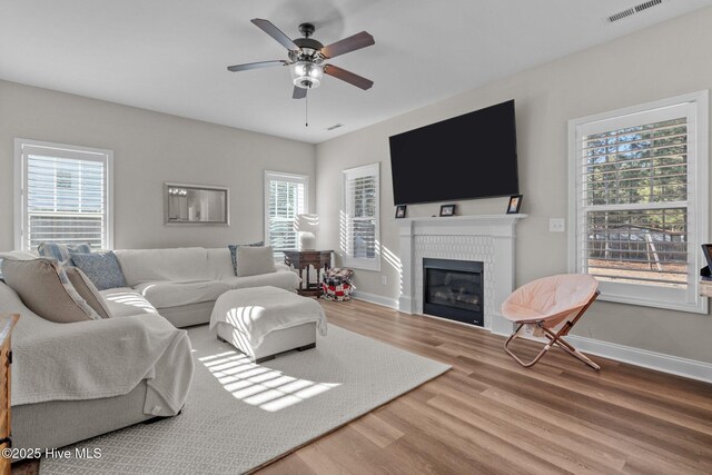 451 Gretchen Rd, West End, NC 27376 - living area with a tile fireplace, wood finished floors, visible vents, a ceiling fan, and baseboards