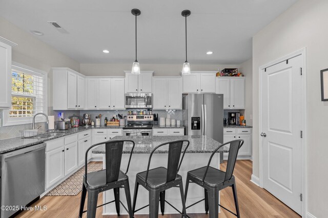 451 Gretchen Rd, West End, NC 27376 - kitchen with white cabinets, stainless steel appliances, light wood finished floors, and a sink
