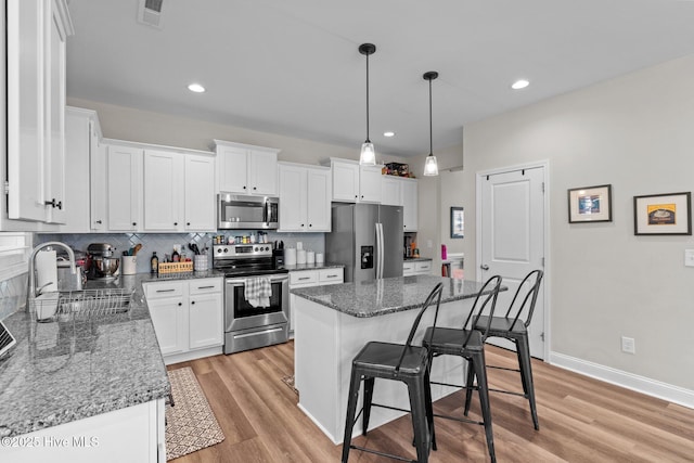 451 Gretchen Rd, West End, NC 27376 - kitchen featuring a sink, appliances with stainless steel finishes, a kitchen bar, white cabinetry, and visible vents