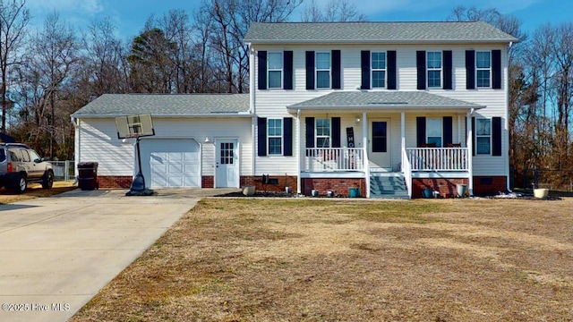 colonial home with a porch, a garage, and a front yard