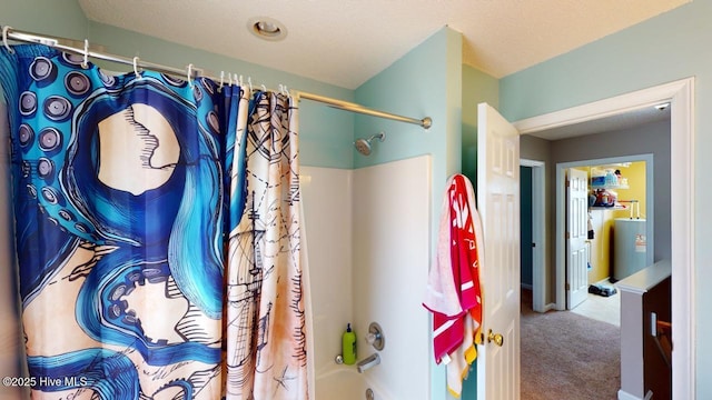 bathroom with shower / tub combo, water heater, and a textured ceiling