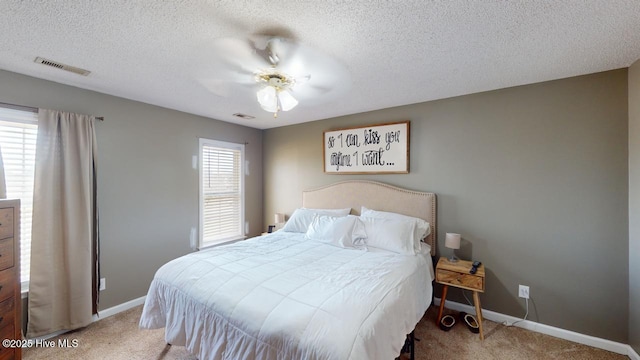 carpeted bedroom featuring ceiling fan and a textured ceiling