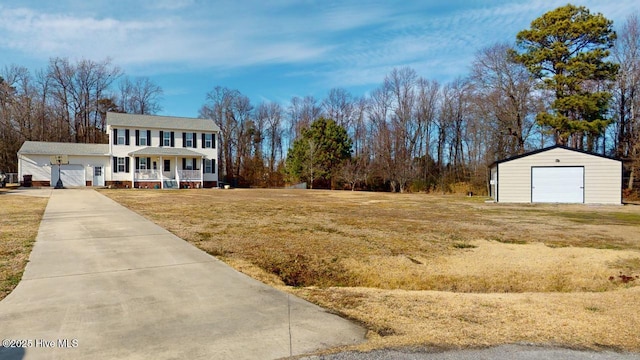 view of front of house with an outbuilding, a garage, a front yard, and covered porch