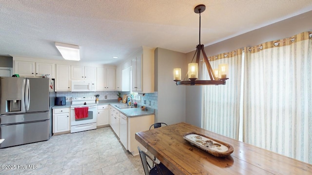 kitchen with white cabinetry, sink, white appliances, and decorative light fixtures