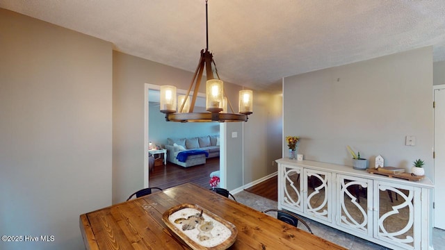 dining room featuring wood-type flooring, a textured ceiling, and a chandelier