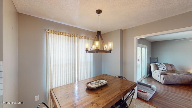 dining room featuring a textured ceiling, a chandelier, and hardwood / wood-style flooring