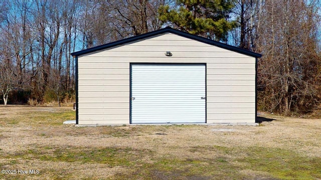 view of outbuilding featuring a garage and a lawn