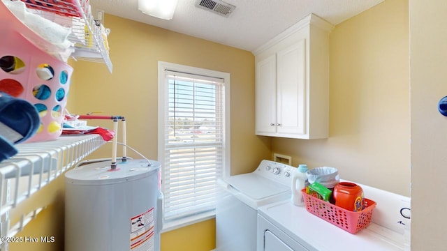 washroom with cabinets, a textured ceiling, water heater, and independent washer and dryer