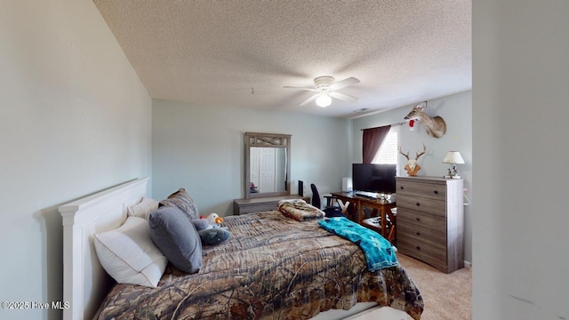 bedroom featuring light colored carpet, a textured ceiling, and ceiling fan