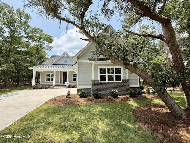 3387 Four Water Ln SW, Supply, NC 28462 - view of front of home with brick siding, a standing seam roof, a front yard, driveway, and metal roof
