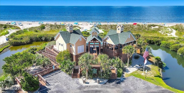 birds eye view of property with a water view and a beach view