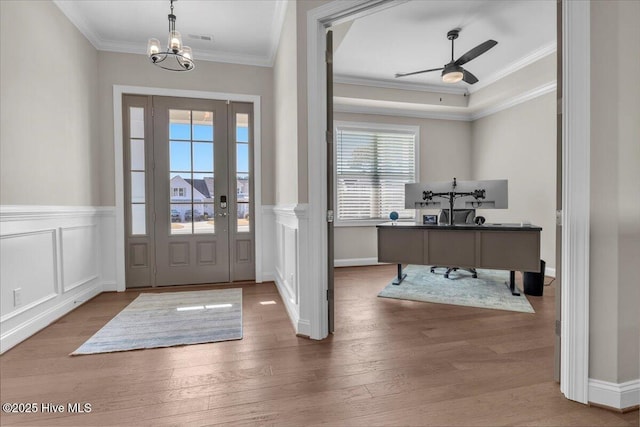 foyer featuring ornamental molding, ceiling fan with notable chandelier, and hardwood / wood-style floors