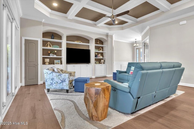 living room with crown molding, coffered ceiling, ceiling fan with notable chandelier, and light hardwood / wood-style flooring