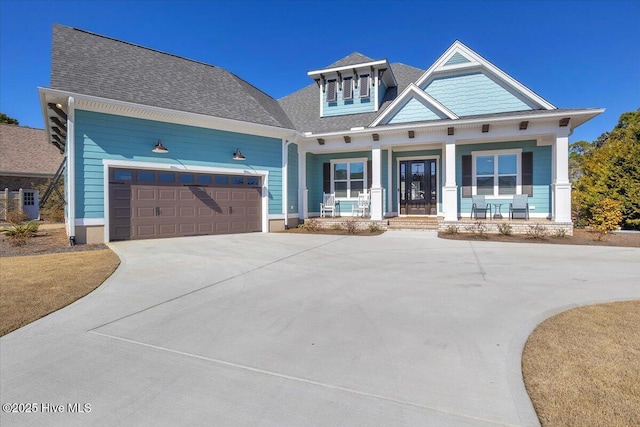 craftsman inspired home featuring a garage and covered porch