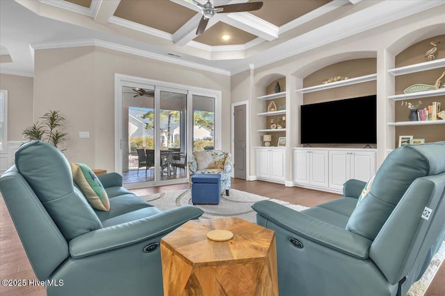 living room with ceiling fan, hardwood / wood-style floors, coffered ceiling, ornamental molding, and built in shelves