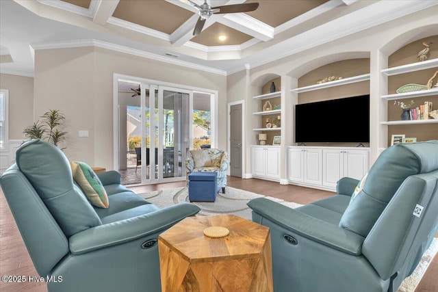 living room with built in features, wood-type flooring, ornamental molding, coffered ceiling, and ceiling fan