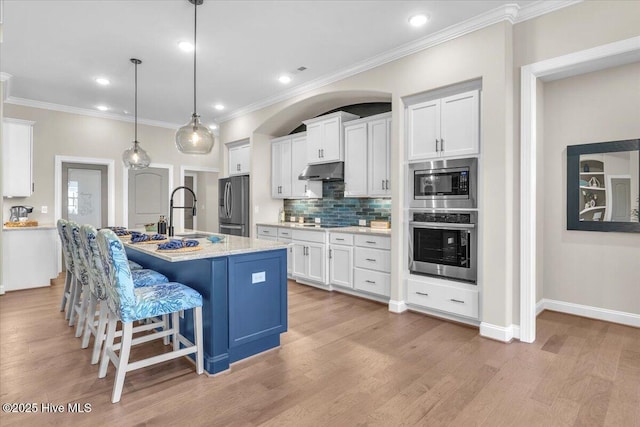 kitchen with a center island with sink, white cabinets, and appliances with stainless steel finishes