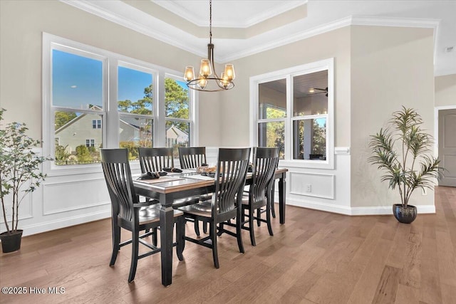 dining area with hardwood / wood-style flooring, ornamental molding, and a wealth of natural light