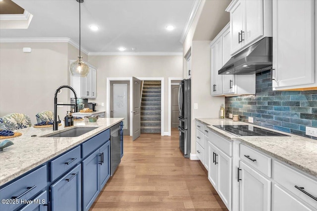 kitchen with sink, white cabinets, hanging light fixtures, light stone countertops, and blue cabinetry