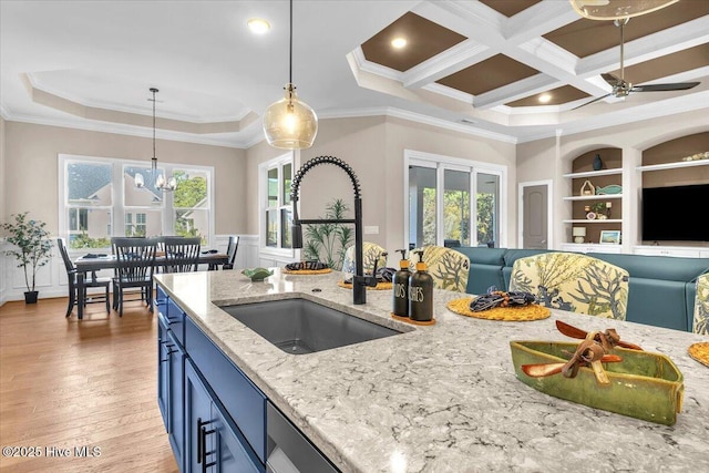 kitchen featuring coffered ceiling, sink, light hardwood / wood-style flooring, ornamental molding, and pendant lighting