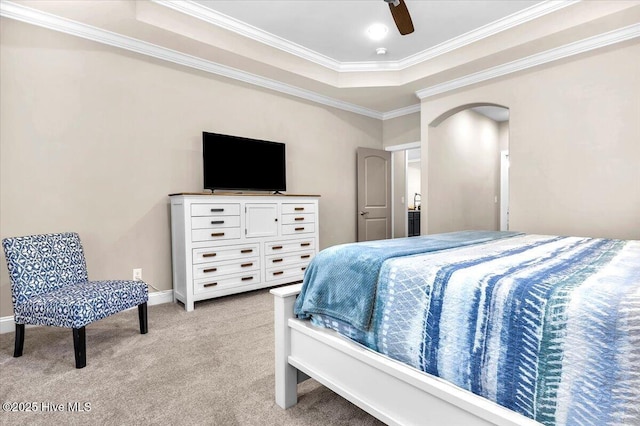 carpeted bedroom featuring crown molding, ceiling fan, and a raised ceiling