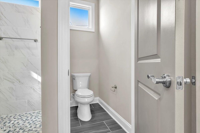 bathroom with tiled shower and toilet